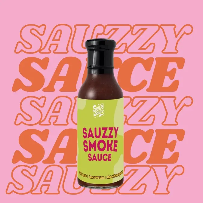 A image of a bottle of Sauzzy Smoke Sauce- the best low calorie, low sugar better for you BBQ sauce- that has the same iconic taste and is made with high quality ingredients. Its packaged in Sauzzy Sauces eco-friendly 100% recycled glass bottles and packaging and is being shown against a background 'Sauzzy Sauce'