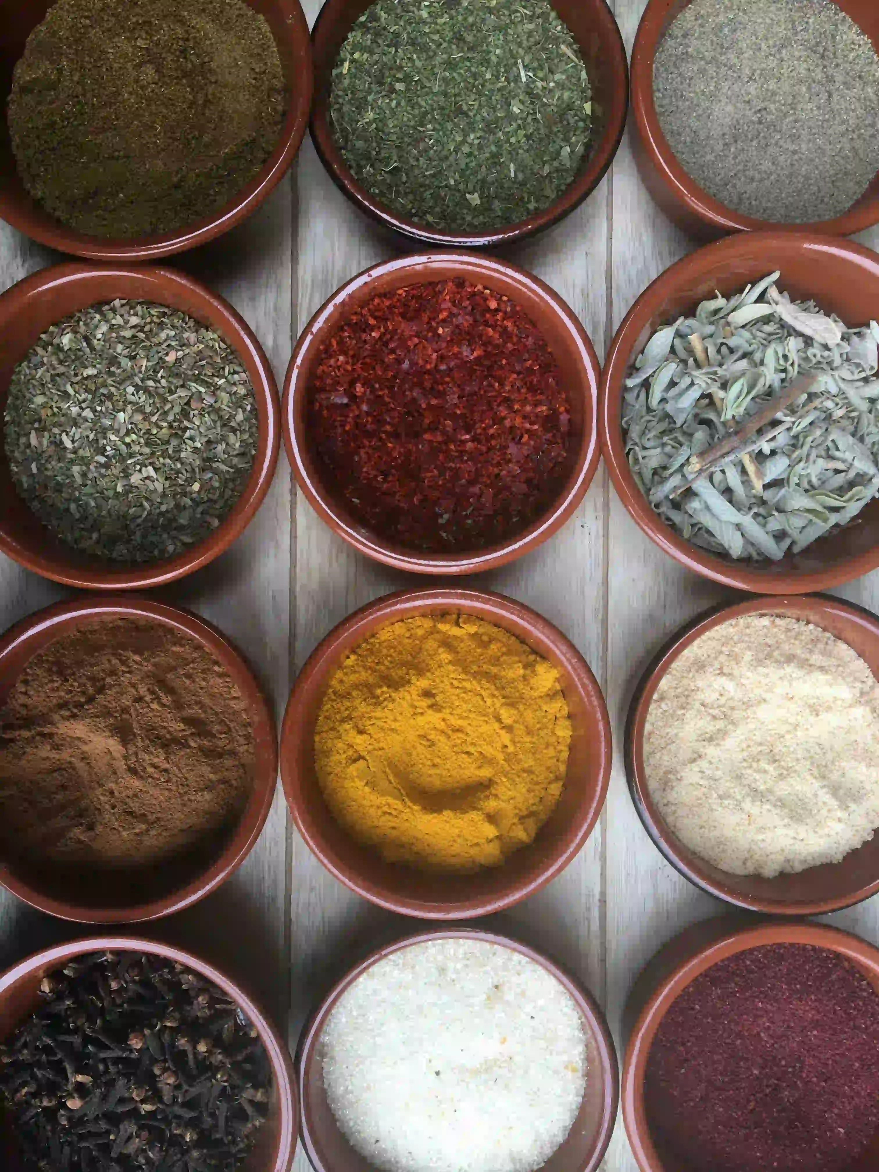 12 diffrent high qulity, organic spices in bowls against a white background 